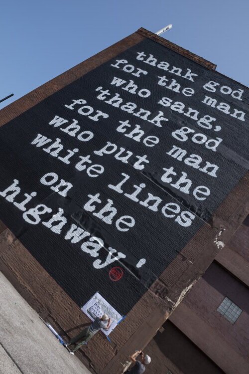 South wall of 2630 Payne Avenue showing the 2,200 SF WRDSMTH Michael Stanley tribute mural, visible from I-90.
